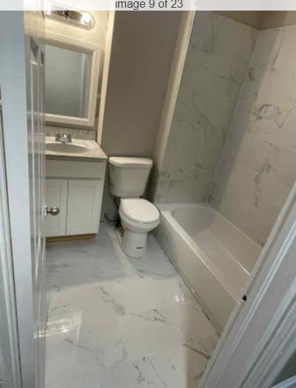 Completed bathroom with vanity, toilet and marble-look tile