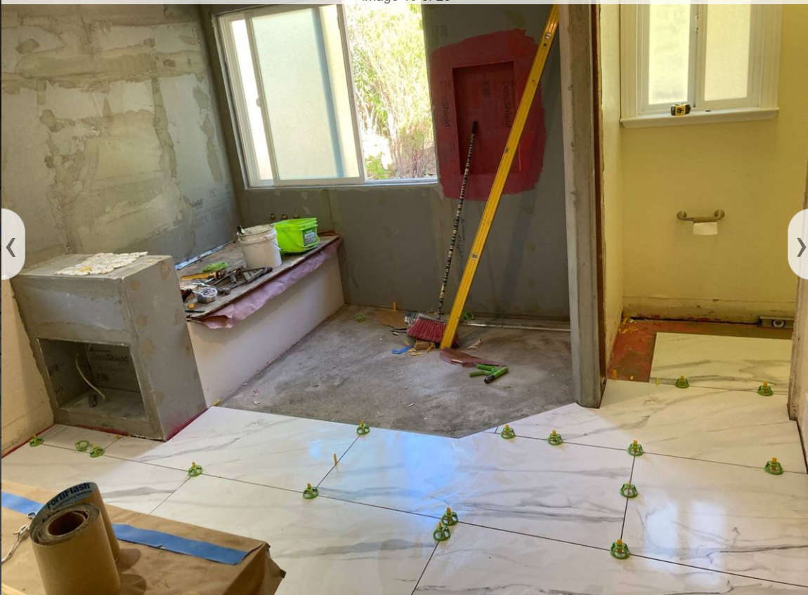 Large format floor tile being installed with leveling spacers