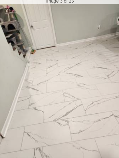Finished marble-look tile flooring with white baseboards